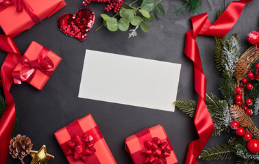 White envelope and Christmas wreath on a black background, top view
