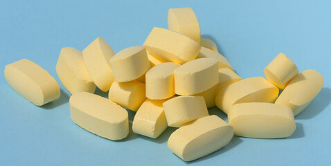 Yellow oval tablets on a blue background