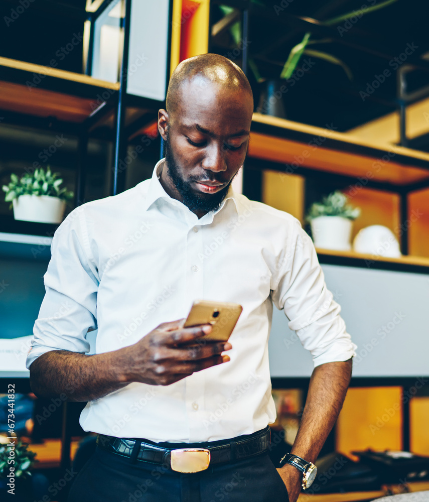 Poster dark skinned businessman checking banking via application on cellular