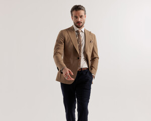 Fototapeta premium cool fashion man with glasses walking with hands in pockets