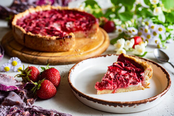 Sweet pastries for the whole family: strawberry pie. Strawberry pie on a large plate and a large piece of pie on a beautiful plate. A piece of strawberry tart on a plate. Close-up