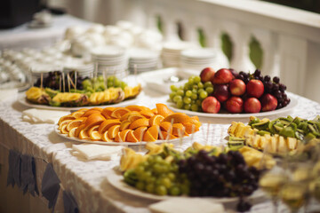 Buffet reception fruit, wines, champagne.fruit plate on wedding table. catering canape assorted fresh fruits, berries and citrus. Fruits for the holidays. Restaurant service at the event.