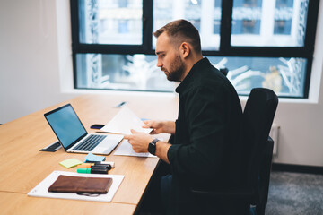 Focused freelancer working on laptop with copy space