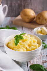 Fresh mashed potatoes and basil leaves in a bowl on the table vertical view