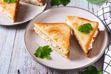 Bacon, egg and herb salad in a trendy chopped grilled sandwich on a plate