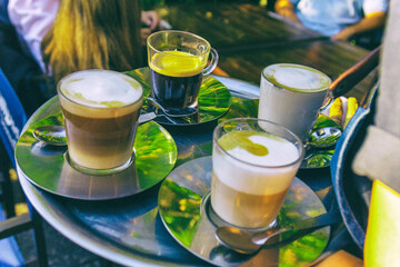 Tazas de cafe en bandeja de bar llevadas por un mozo
