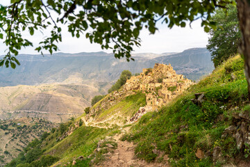 Dagestan Gamsutl. Ancient ghost town of Gamsutl old stone houses in abandoned Gamsutl mountain village in Dagestan, Abandoned etnic aul, summer landscape.