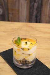 Fruity desserts. Closeup view of a glass with passion fruit mousse, with oatmeal and nuts.	
