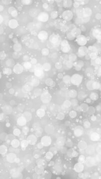 Silver white winter bokeh with flickering stars loop vertical background. Concept Christmas and New Year copy space, animation.