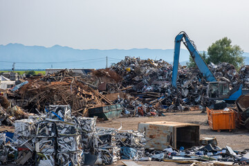 Industrial scrap metal recycling in junkyard. Clow crane picking up metal, aluminum, brass, copper, stainless steel. Recycling industry. Environment and zero waste concept - obrazy, fototapety, plakaty