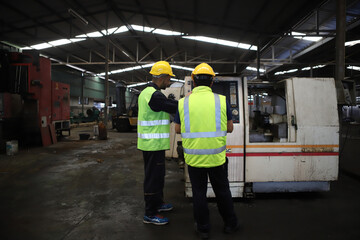 worker or engineer working in factory with safety uniform , safety hat and safety glasses , image is safety concept or happy workplace