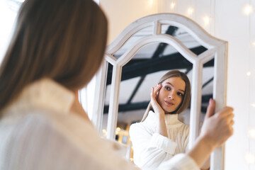 Smiling woman admiring herself in mirror
