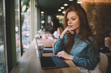 Young woman with coffee and laptop sitting in cafe