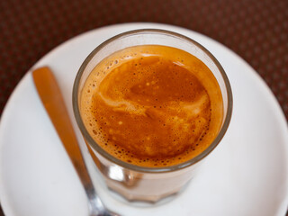 Mug of cortado served on table in cafe. Traditional Spanish coffee.