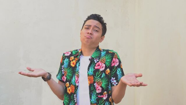 Curly man Indonesian wear the beachwear with i don't know gesture.  The footage is suitable to use for man expression advertising, fashion life style.