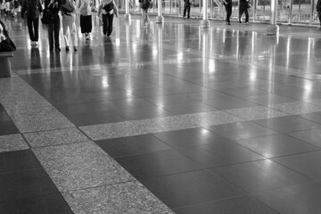 光を反射してキラキラ光る道を歩く人。jr大阪駅構内で撮影