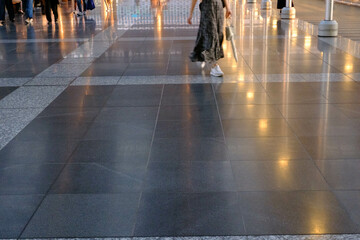 光を反射してキラキラ光る道を歩く人。jr大阪駅構内で撮影 - obrazy, fototapety, plakaty