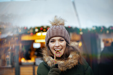 smiling young woman at winter fair in city - obrazy, fototapety, plakaty
