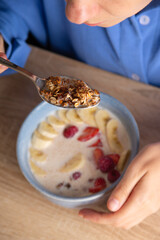 Healthy breakfast concept. Woman eats granola with fruit.