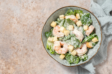 Fresh caesar salad on bowl with parmesan cheese and shrimps