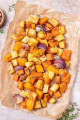 Oven-baked vegetables on a baking sheet. Baked pumpkin, potatoes, carrots and onions. Cooking dinner in the oven. Vegetarian food in the oven.