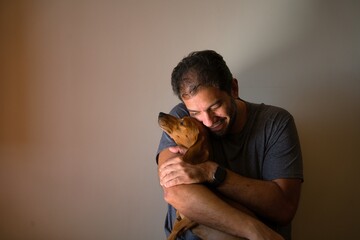 Adult embracing their pet, a Dachshund dog