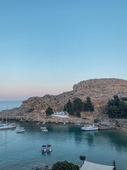 Fototapeta na wymiar Lindos, Paralia isola di Rodi, Rhodos. Sole, mare e tramonto; montagne, colline città antica e acropoli.