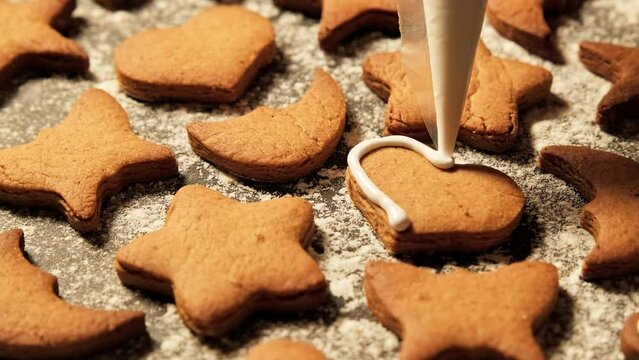 Gingerbread Christmas cookies icing. Gingerbread heart filling with white glaze. Homemade sugar biscuits. Christmas cookies with icing. Close-up in 4K, UHD