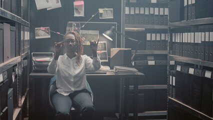 Professional officer analyzing clues on hologram, working with augmented reality in law enforcement agency. Female inspector moving holographic image of evidence, artificial intelligence.