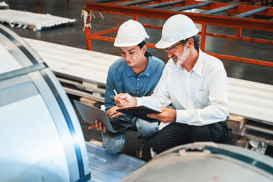 Metalwork manufacturing factory manager inspect newly manufactured metal or steel roll and frame in factory. Inspection and quality control process ensure highest quality product. Exemplifying