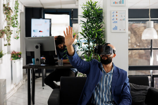 Business worker using vr technology for project presentation in startup company workplace. Entrepreneur wearing virtual reality headset to simulate product design and development - Powered by Adobe