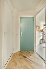 an empty room with a blue door and wood floor in the center of the room is a white wall that has been painted