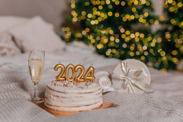a cake with 2024 candles in Christmas decorations. A glass of champagne. Preparations for family...