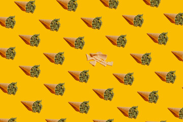 Cannabis buds in a food cone. Creative food concept. Pattern on a yellow background - 673523865
