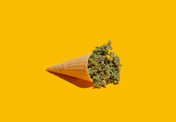 Cannabis buds in a food cone. Creative food concept. On a yellow background - 673523871