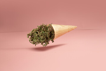 Cannabis buds in a food cone. Creative food concept. On a pastel background - 673523879