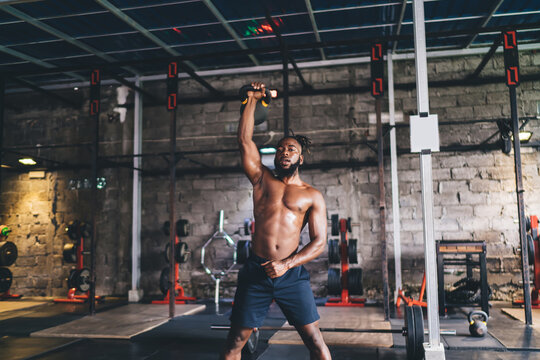 Strong African American man exercising with dumbbell