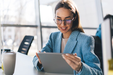 Smiling woman using tablet at table in office