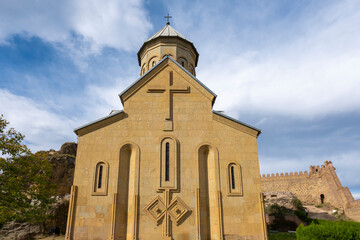 tbilisi city and Narikala small castle with church inside on a cloudy day and blue clouds in the sky