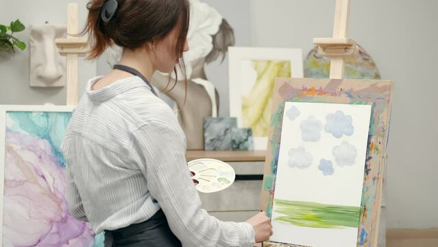 girl painting expressing herself and showing her hobby in a colored painting 