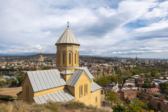 tbilisi city and Narikala small castle with church inside on a cloudy day and blue clouds in the sky