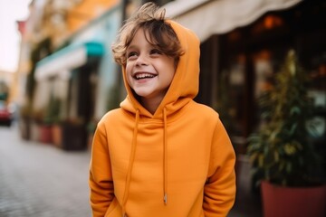 Portrait of a smiling boy in a yellow hoodie on the street