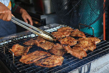 Grilled pork neck on the grill. Eat with With spicy sauce, soft and chewy, very delicious taste. Restaurant menu. Thai food style