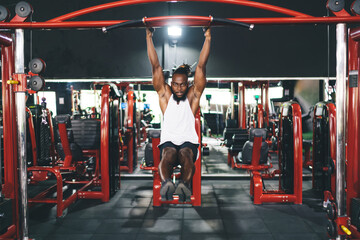 Black man doing pull ups in gym