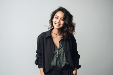 young beautiful asian woman smiling and looking at camera isolated on grey background