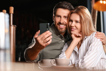 Romantic date. Happy couple taking selfie in cafe