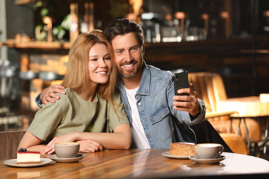 Romantic date. Happy couple taking selfie in cafe