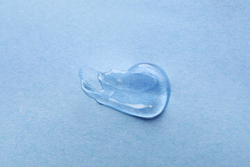 Sample of transparent gel on light blue background, closeup
