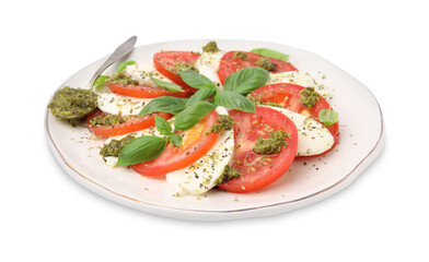 Plate of delicious Caprese salad and spoon with pesto sauce isolated on white