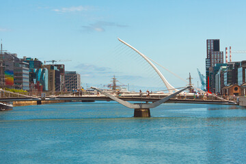 Fototapeta premium Discovering Ireland concept. A view to Samuel Beckett Bridge over River Liffey in Dublin city. Sunny day. Text space. Outdoor shot
